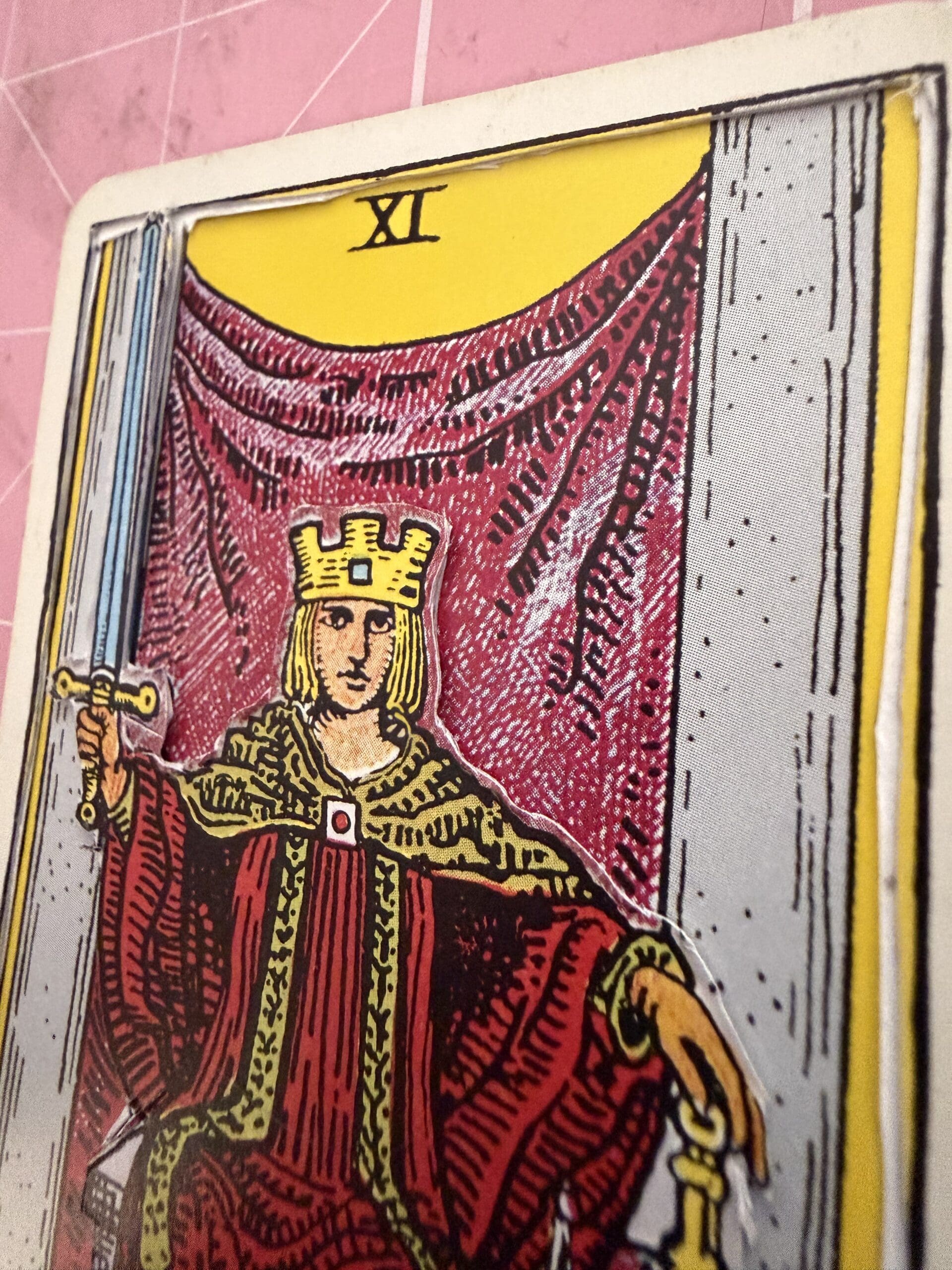 Close-up of Justice tarot card showing 3D layered handcrafted texture and detail