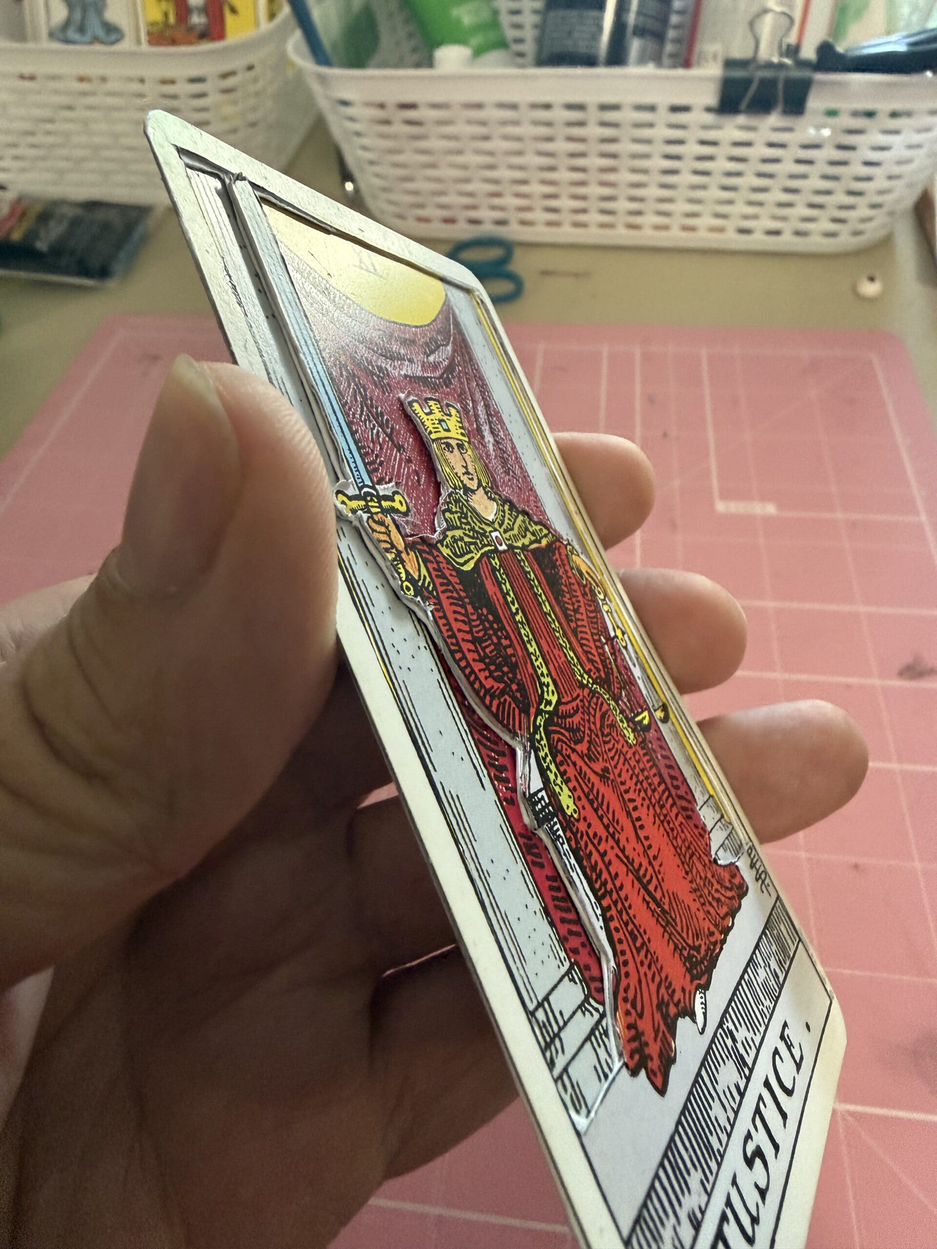 Side view of Justice tarot card showing 3D layered handcrafted detail